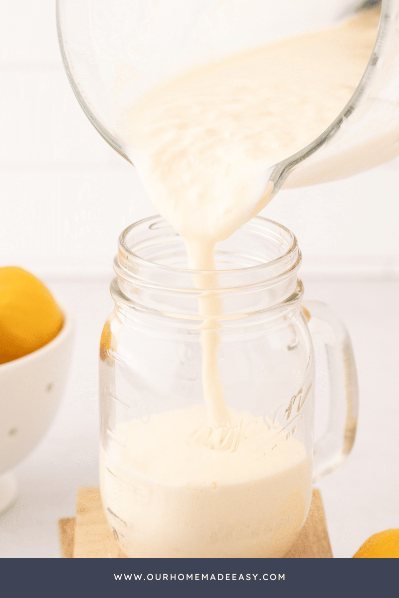 Pouring frosted lemonade into drink glass