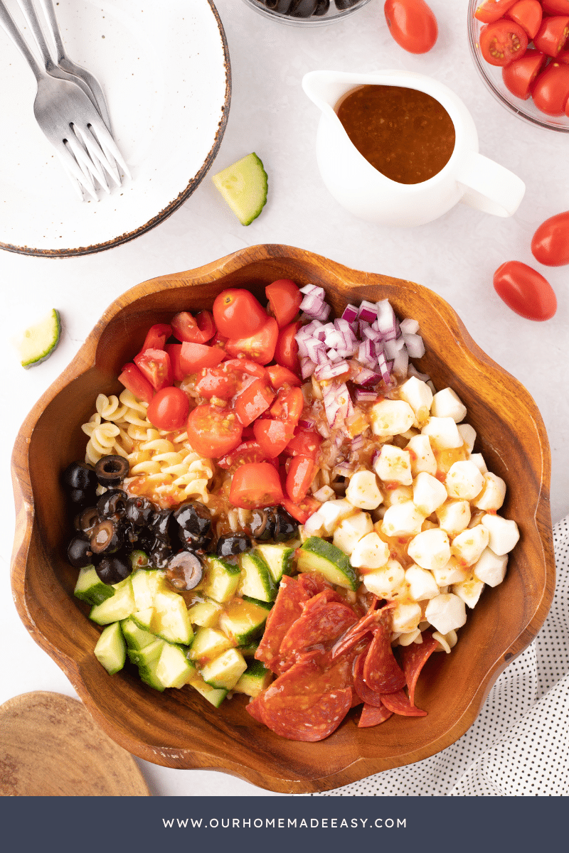 Italian Pasta Salad being made in wooden bowl