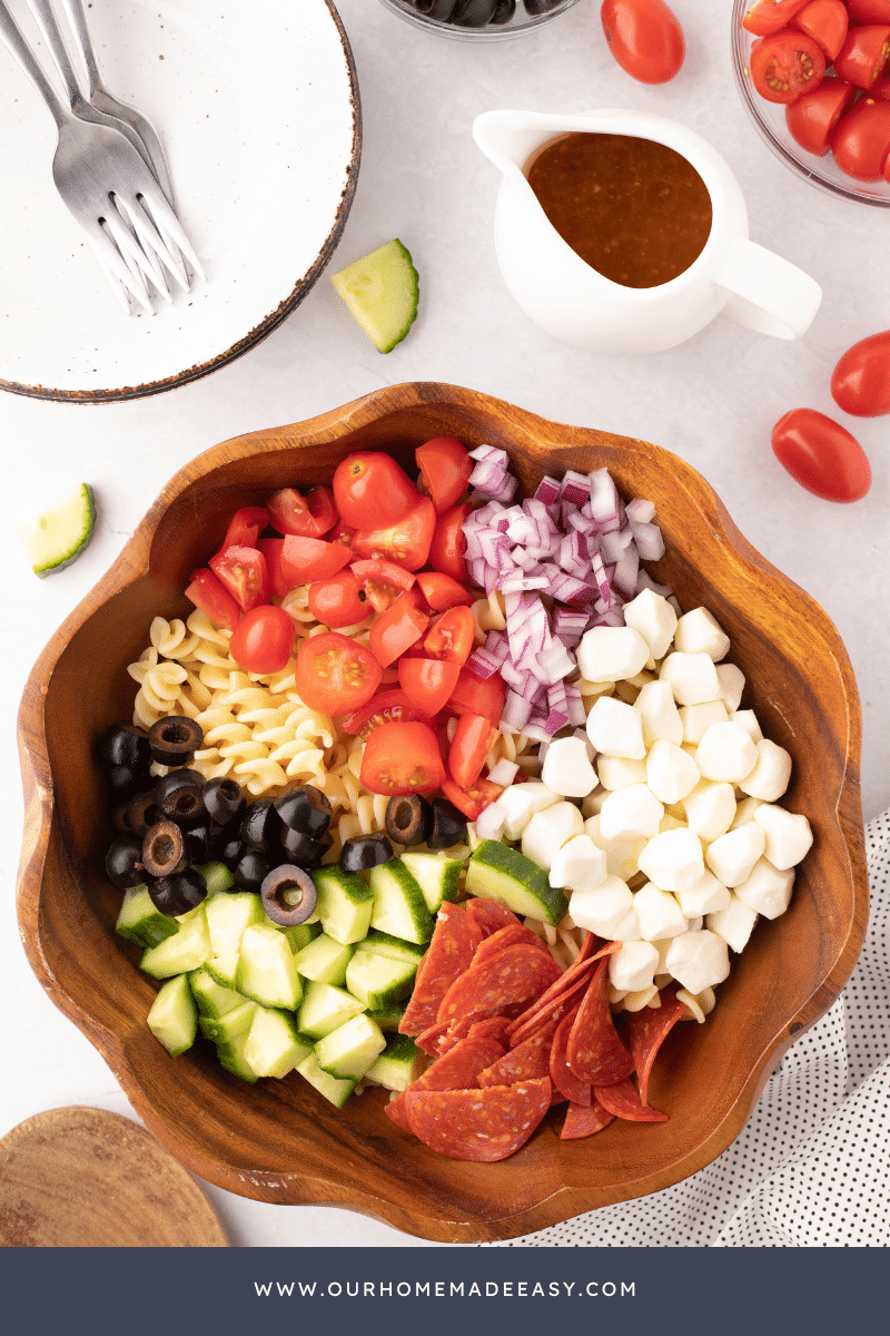 Italian Pasta Salad being made in wooden bowl