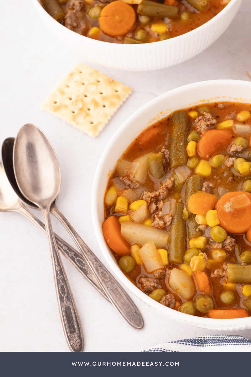 Hamburger vegetable soup in ceramic bowl with utensils