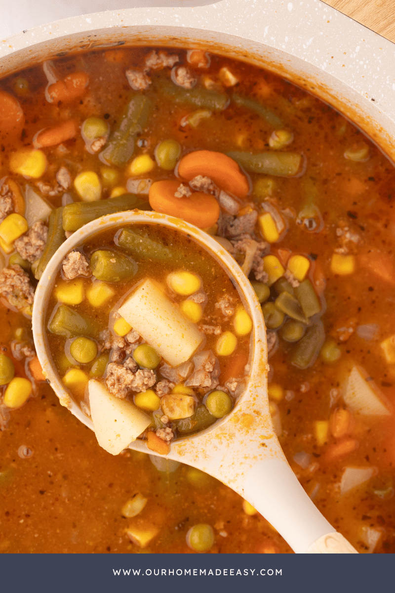 Wooden spoon holding vegetable beef soup