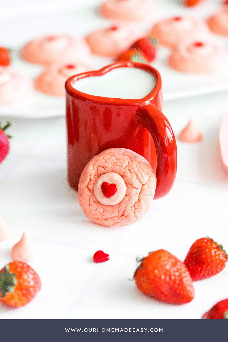 strawberry cake mix cookie propped up by red heart mug