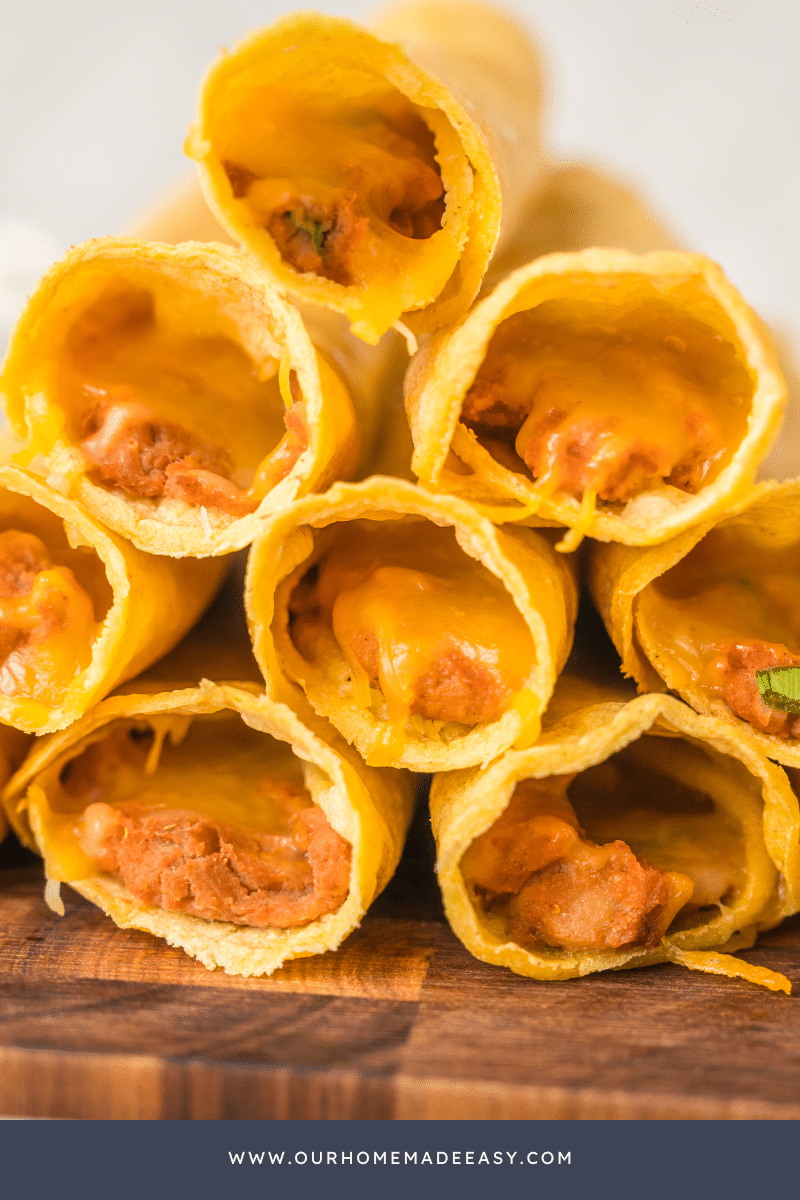 Stack of finished vegetarian taquitos on cutting board