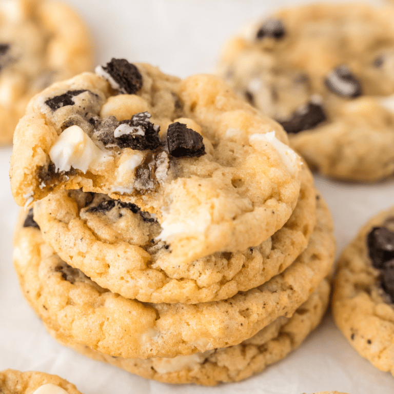 Soft Cookies and Cream cookies stacked on baking sheet