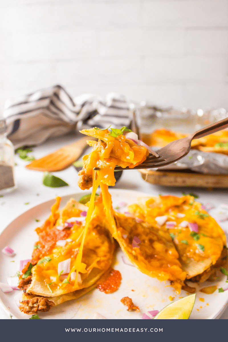 Fork holding up bite of melted tacos