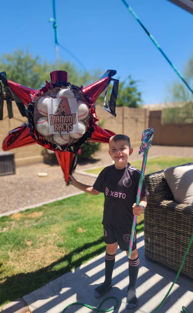 boy standing next to pinata