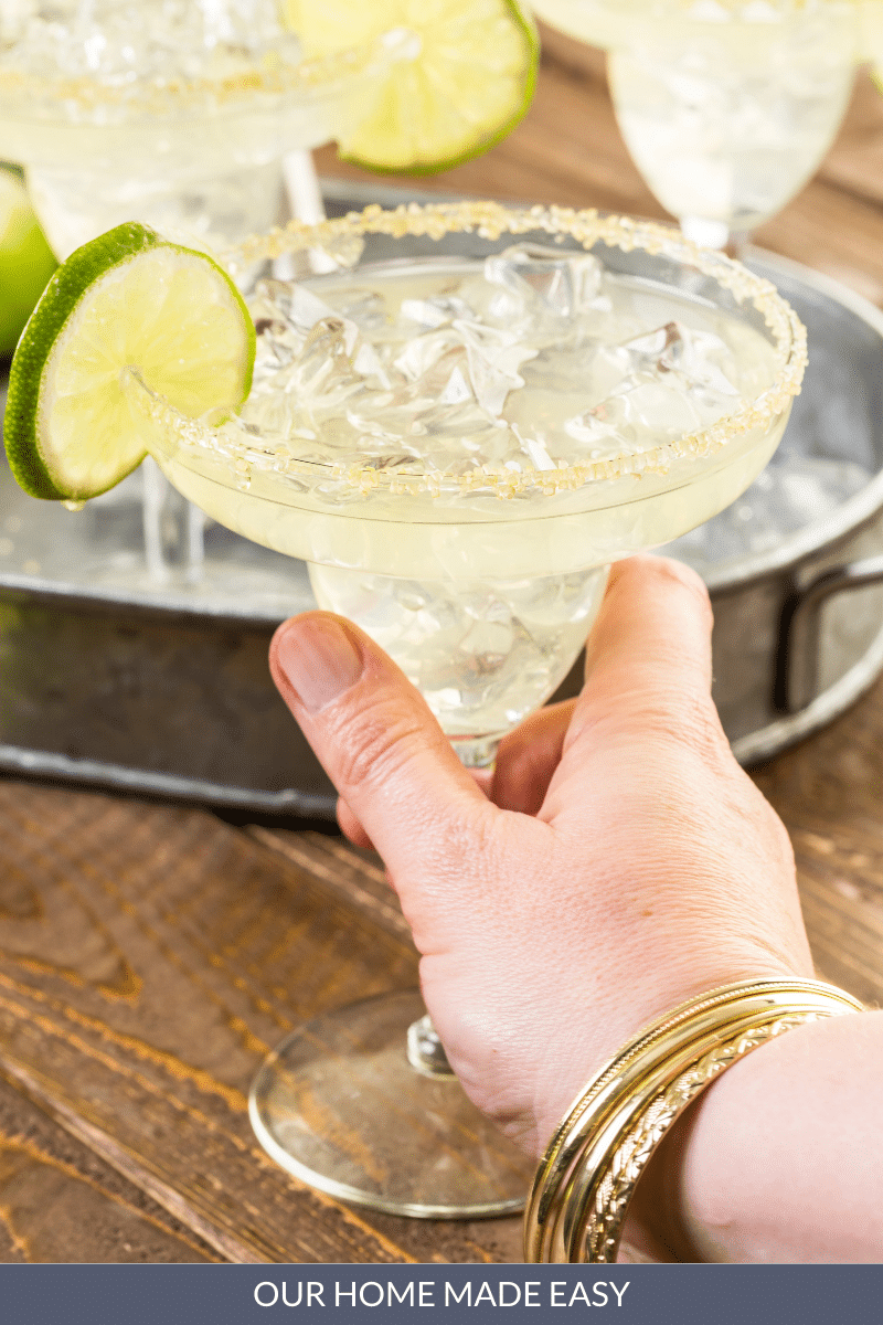 woman holding a margarita in glass